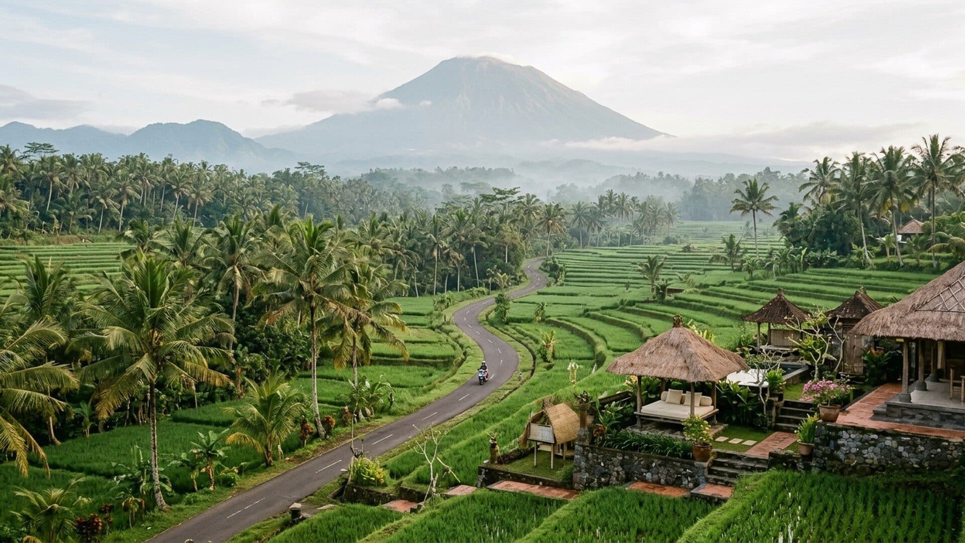 The narrow road into the Sidemen valley between rice terraces, Mount Agung in the distance